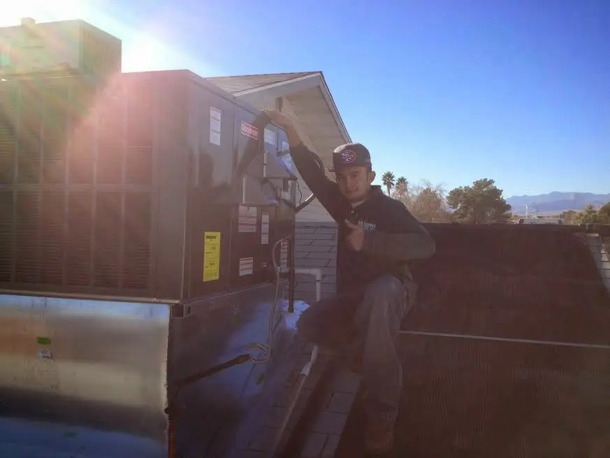 HVAC technician performing Air Duct Repair on a rooftop unit in York